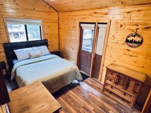 a bedroom with a bed in a log cabin at Pet Friendly Retreat in Rim Country! With a Spa! in Mogollon Airpark