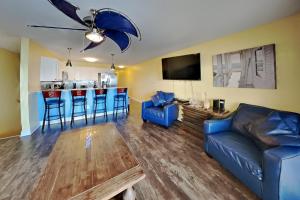 a living room with a blue couch and a bar at Put-In-Bay Waterfront Condo #108 in Put-in-Bay +25 photos