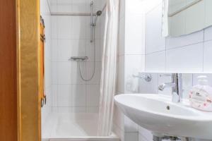 ein weißes Badezimmer mit Waschbecken und Dusche in der Unterkunft Apartment K & K in Baška Voda + 18 Fotos