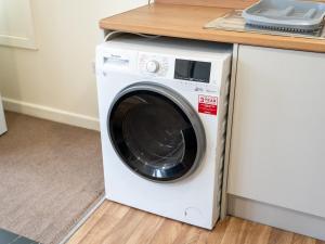 a white washing machine sitting next to a counter at Plumtree in Manchester