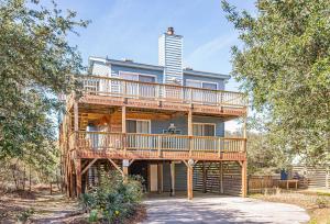a tree house with a deck on the side of it at Misty Blue in Corolla