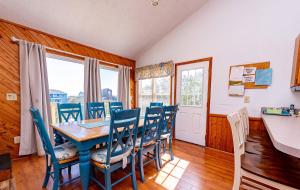 a dining room with a blue table and chairs at Misty Blue in Corolla