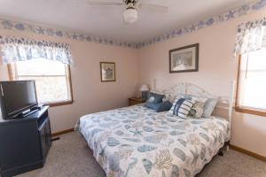 a bedroom with a bed and a flat screen tv at Misty Blue in Corolla
