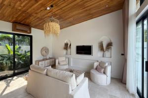 波普托Golden Palm Pool Villa near Fishermans Village的客厅配有白色家具和吊灯。