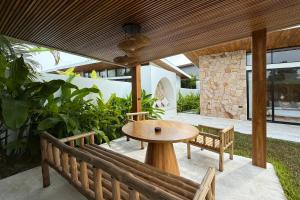 波普托Golden Palm Pool Villa near Fishermans Village的天井配有木桌和长凳