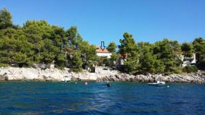 a body of water with a house in the background at Apartment Mila in Brna