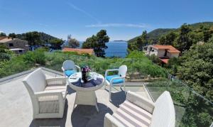 a patio with chairs and a table with a view of the ocean at Apartment Mila in Brna