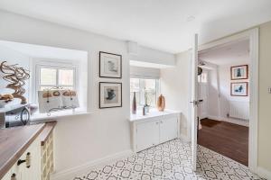 a kitchen with white walls and a white counter top at Bakers Cottage in Shaftesbury +34 photos