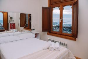 two beds in a room with two windows at Céntrico con vistas a la ría by CABANA Rentals in Vigo
