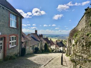 an empty street in a village with buildings at Bakers Cottage in Shaftesbury
