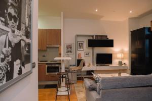 a living room with a couch and a kitchen at Céntrico con vistas a la ría by CABANA Rentals in Vigo