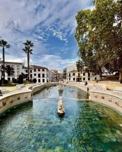 una fontana nel mezzo di un cortile con edifici di La Tesela a Priego de Córdoba