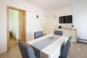 a dining room with a table and chairs and a kitchen at Apartment Lucy in Kožino