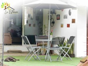 une table, des chaises et un chien dormant sous un parapluie dans l'établissement Casa de Campo - Jacuzzi y Río en Santo Domingo, à Santo Domingo de los Colorados 22 autres photos