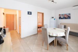 a kitchen and dining room with a table and chairs at Apartment Lucy in Kožino
