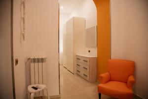 une chaise orange dans une chambre avec commode dans l'établissement HELLO CHIAIA NAPOLI by Progecta srl, à Naples 58 autres photos