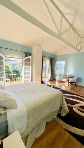 a bedroom with a large bed and a table at Casa Girassol in Teresópolis