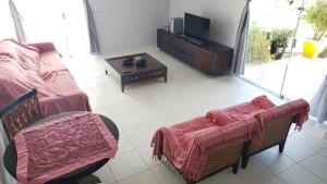 a living room with a couch and a tv at Sonho de Verão in Paripueira