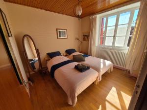Saint-Symphorien-de-ThénièresにあるMaison La vie de l'Aubrac - Gîte Lo Bel Peisの大きな窓のある部屋にベッドが2つある +58枚の写真