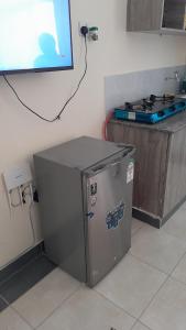 a small refrigerator in a kitchen next to a tv at MJ homes in Mtwapa +9 photos