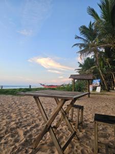 a wooden picnic table on a sandy beach at Suda Villa Bentota in Bentota