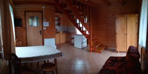 a kitchen with a table and a staircase in a cabin at Agroturystyka Pod Bocianami Terka in Polańczyk