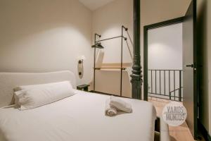 a bedroom with a white bed with a clock on it at Dulce descanso para 10, ven a Duque de Rivas 8 E3 in Madrid