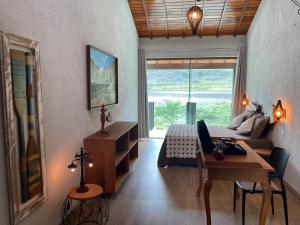 a bedroom with a bed and a desk with a laptop at Casa da Prainha Lapinha da Serra in Santana do Riacho