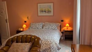 a bedroom with a bed and a couch and two lamps at Hotel La Rotonda in Cepagatti