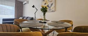 a table and chairs with a vase of flowers on it at 111 apartment in Čakovec