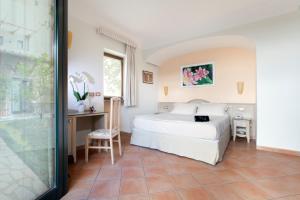 1 dormitorio con 1 cama blanca grande y escritorio en Relais Villa Angiolina, en Sorrento