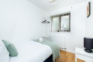 a white bedroom with a bed and a window at Contractor & Business Stays Birchwood Bus Park in Risley