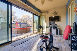 einen Fitnessraum mit einem Fitnessraum und einem Laufband in der Unterkunft Putting Green and Hot Tub Goodyear Retreat! in Goodyear