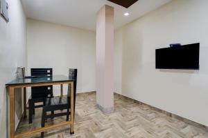 a room with a table and a tv on a wall at Buraimi Apartments in Cochin