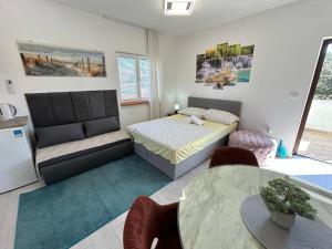 een slaapkamer met een bed, een tafel en stoelen bij Villa Daja in Biograd na Moru