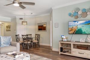 salon z płaskim telewizorem na ścianie w obiekcie Paradise Shores 305 by Pristine Properties Vacation Rentals w mieście Mexico Beach