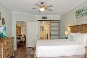 sypialnia z łóżkiem i wentylatorem sufitowym w obiekcie Paradise Shores 305 by Pristine Properties Vacation Rentals w mieście Mexico Beach +31 zdjęć