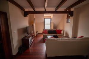 a living room with a couch and a tv at Ático espectacular Comillas a 2 Km in Liandres