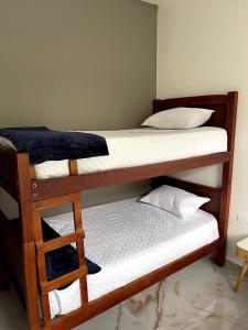 two bunk beds in a room with a ladder at Casa Eterno Sol B&B in Catamayo