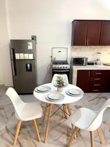 a kitchen with a table and chairs and a refrigerator at Casa Eterno Sol B&B in Catamayo