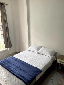 a bedroom with a bed with a blue blanket on it at Casa Eterno Sol B&B in Catamayo