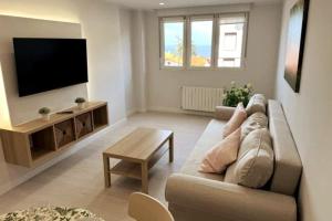 a living room with a couch and a flat screen tv at Apartamento Araceli in Suances
