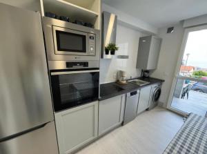 a kitchen with stainless steel appliances and a window at Apartamento Araceli in Suances