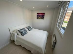 a bedroom with a bed with two pillows on it at Apartamento Araceli in Suances