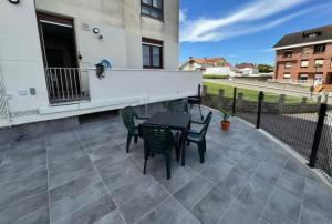 a patio with a table and chairs and a building at Apartamento Araceli in Suances
