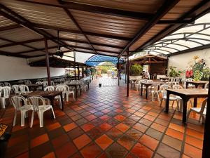 ein Restaurant mit Tischen und Stühlen und einem gefliesten Boden in der Unterkunft Hotel Olímpica in La Ceja