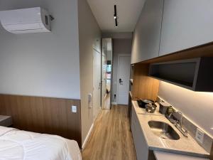 a hotel room with a bed and a sink at Studio Moderno ao lado do Metrô Alto da Ipiranga in Sao Paulo
