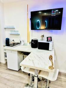 a kitchen with a white counter with a table at Suites DUBAI chambre privée avec espaces communs in Perpignan