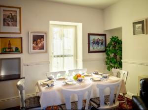 a dining room table with white chairs and a white table cloth at White Heather 3 Bed Clifden Town in Clifden
