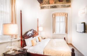 a bedroom with a bed and a television in it at The Dominican in Prague
